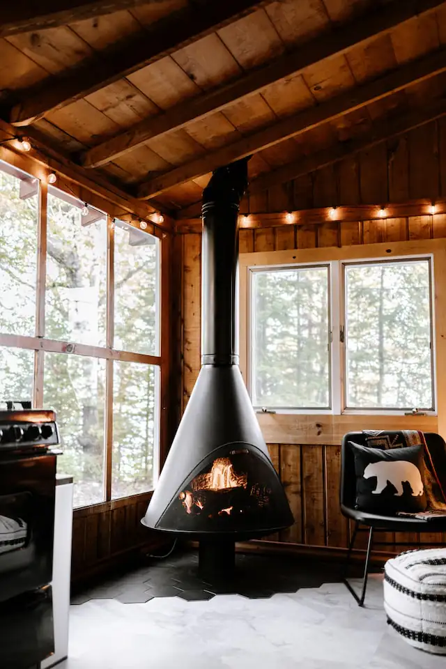 Modern suspended fireplace, Newcastle upon Tyne Black suspended fireplace in a wood-panelled living room with tall windows